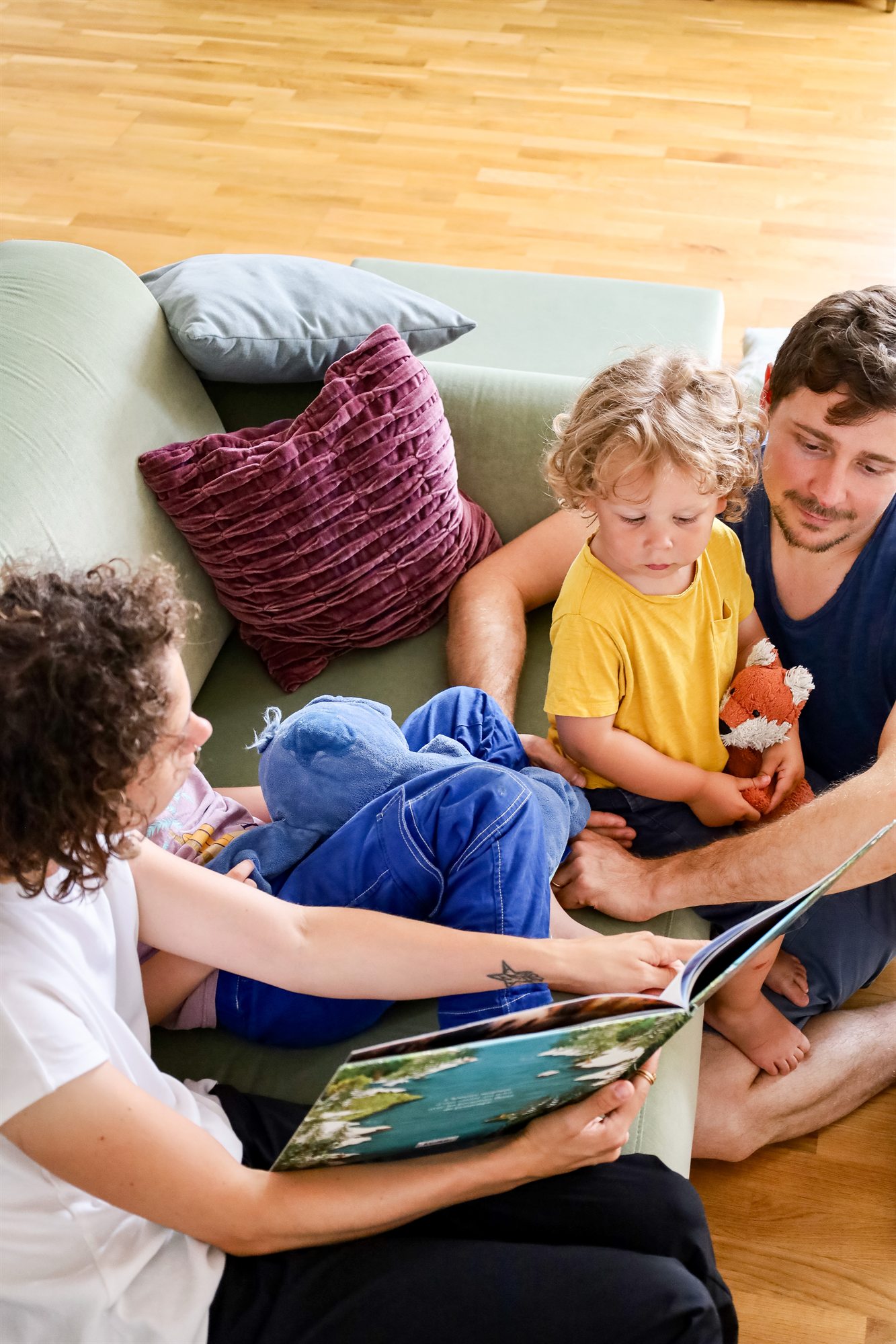 Une famille partage un moment de lecture dans un appartement de la Résidence de l'Arsenal Royal