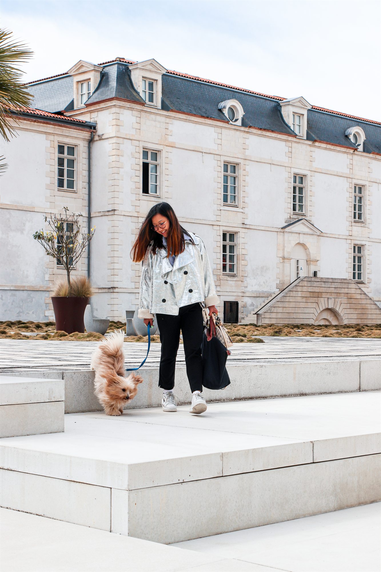 Une résidente et son chien sur le parvis de la Résidence de l'Arsenal Royal