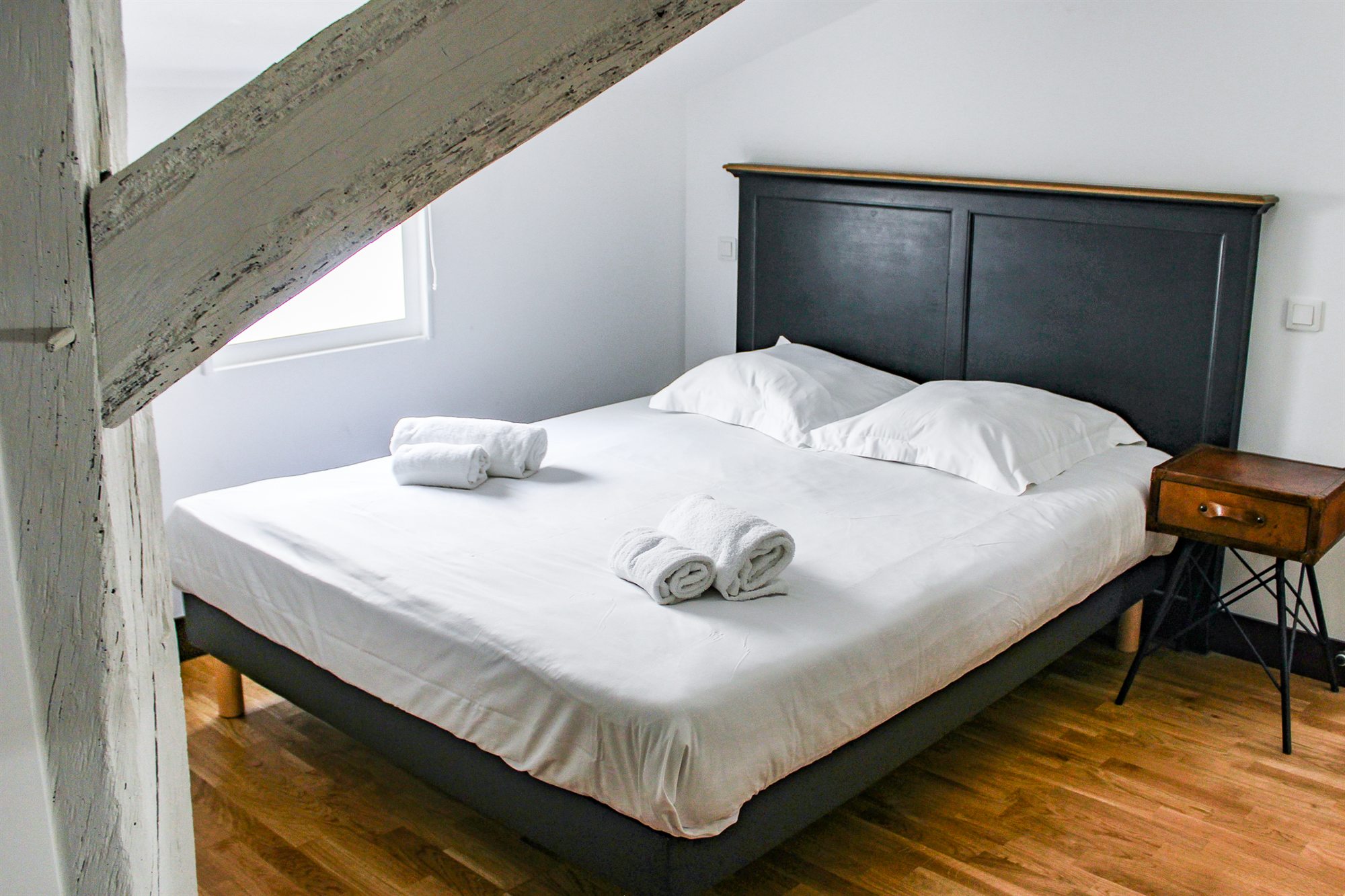 Chambre sous charpente apparente avec lit double