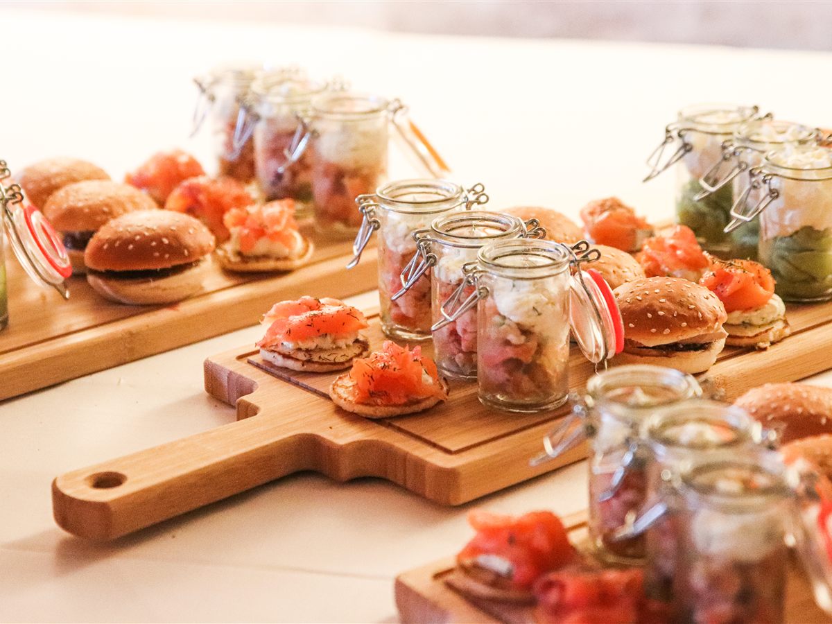 Verrines, mini burgers et blinis dressés sur des planches