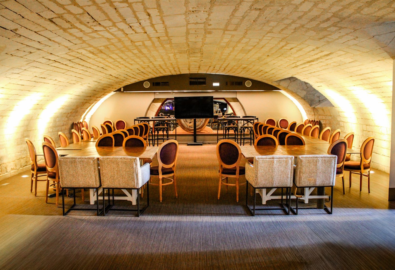 Le Salon de la Résidence de l'Arsenal Royal, salle voûtée en pierre aménagée pour une réunion