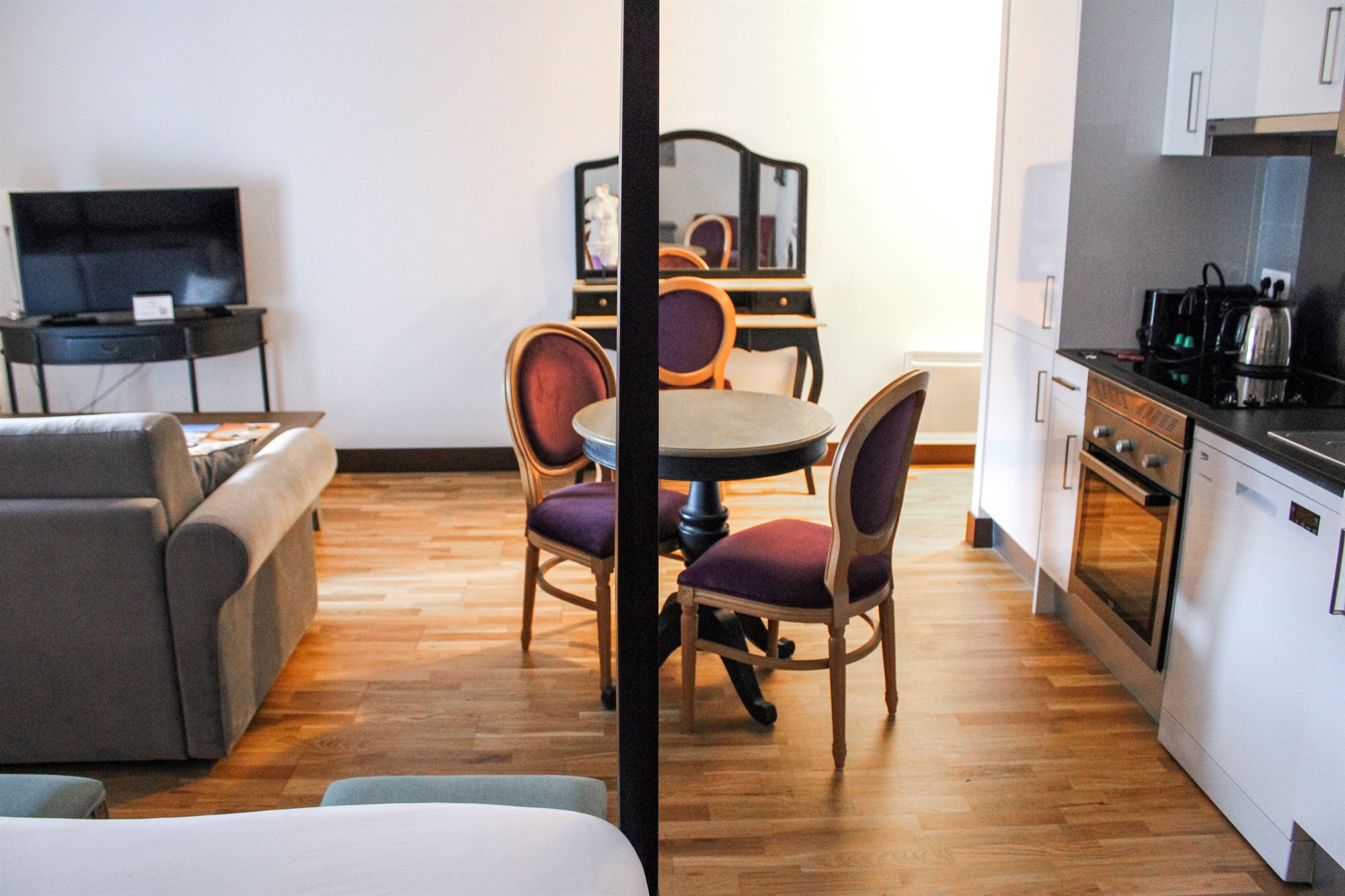 Studio T1 — le coin salon avec canapé, télévision et table à manger