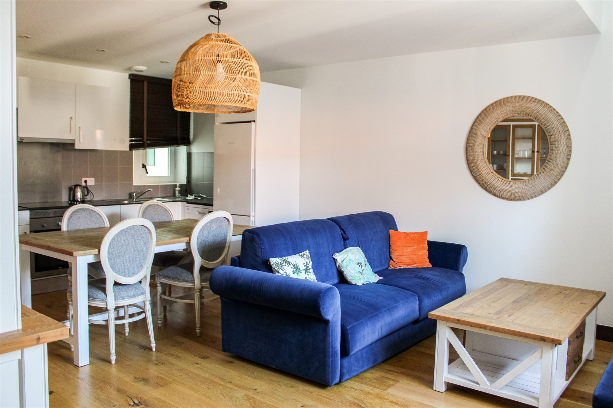 Appartement T2 — séjour avec canapé, coin repas et cuisine ouverte
