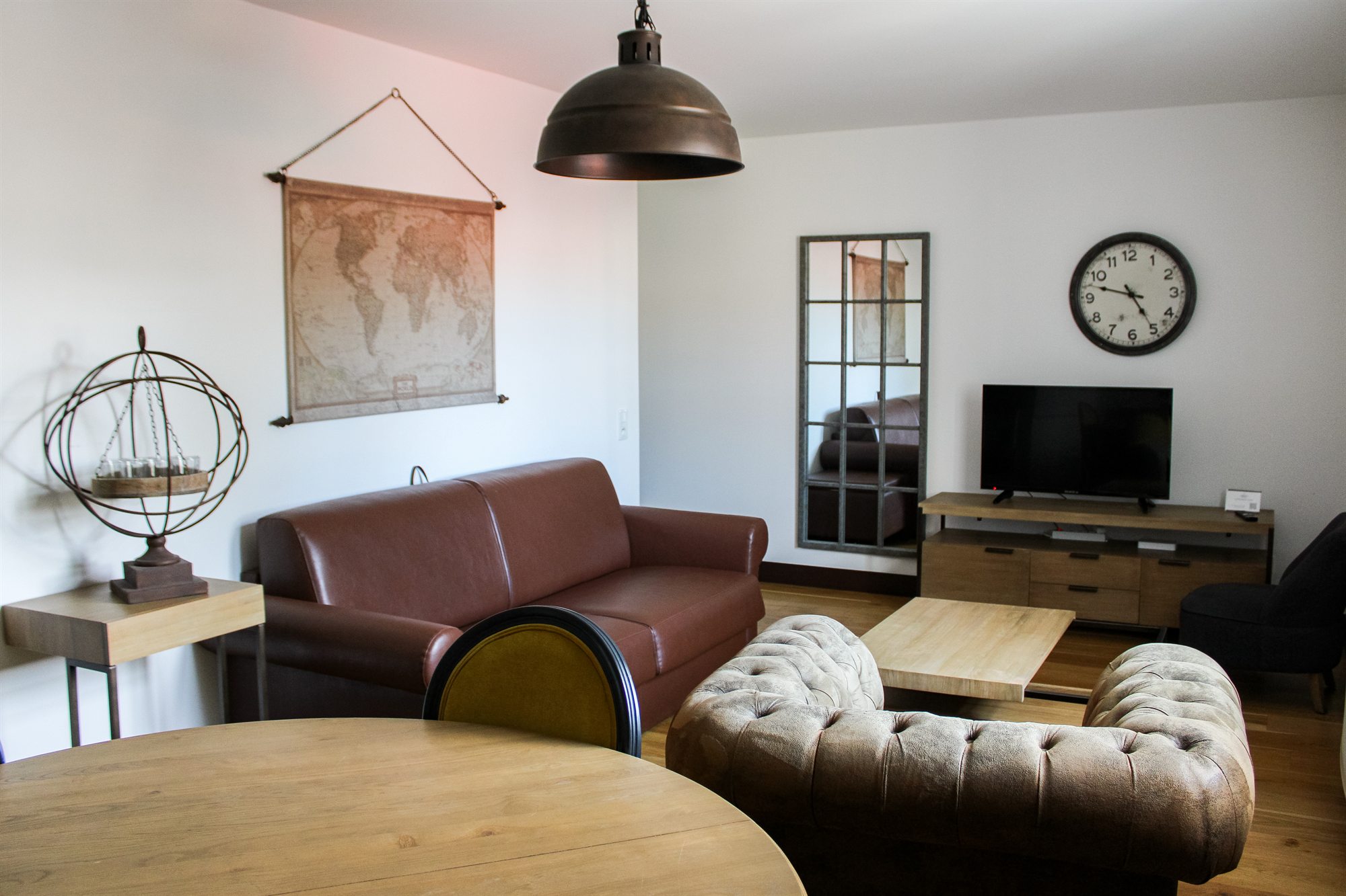 Appartement T3 — coin salon avec canapé, table ronde et télévision