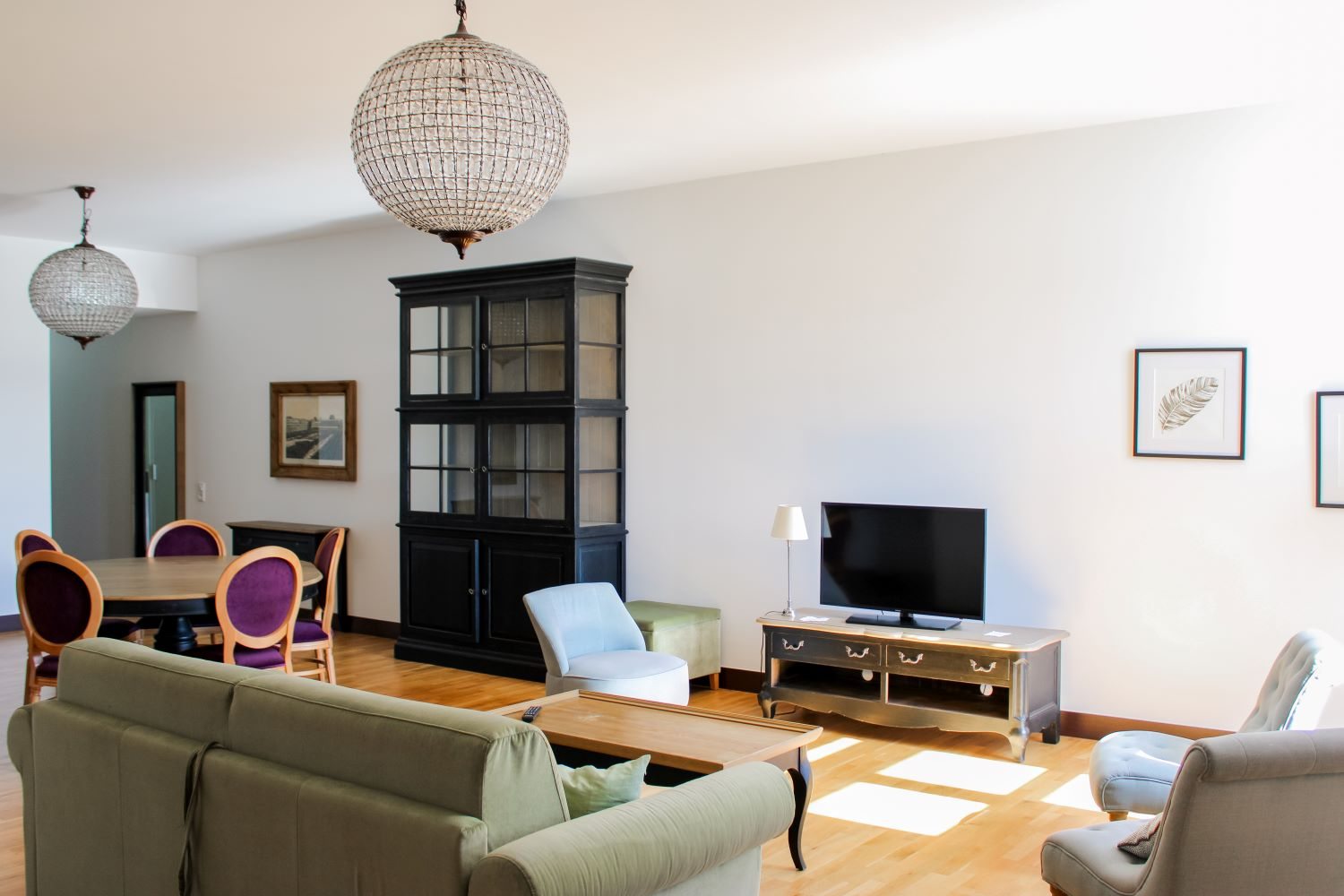Appartement T4 — le coin salon avec canapé, télévision et vaisselier