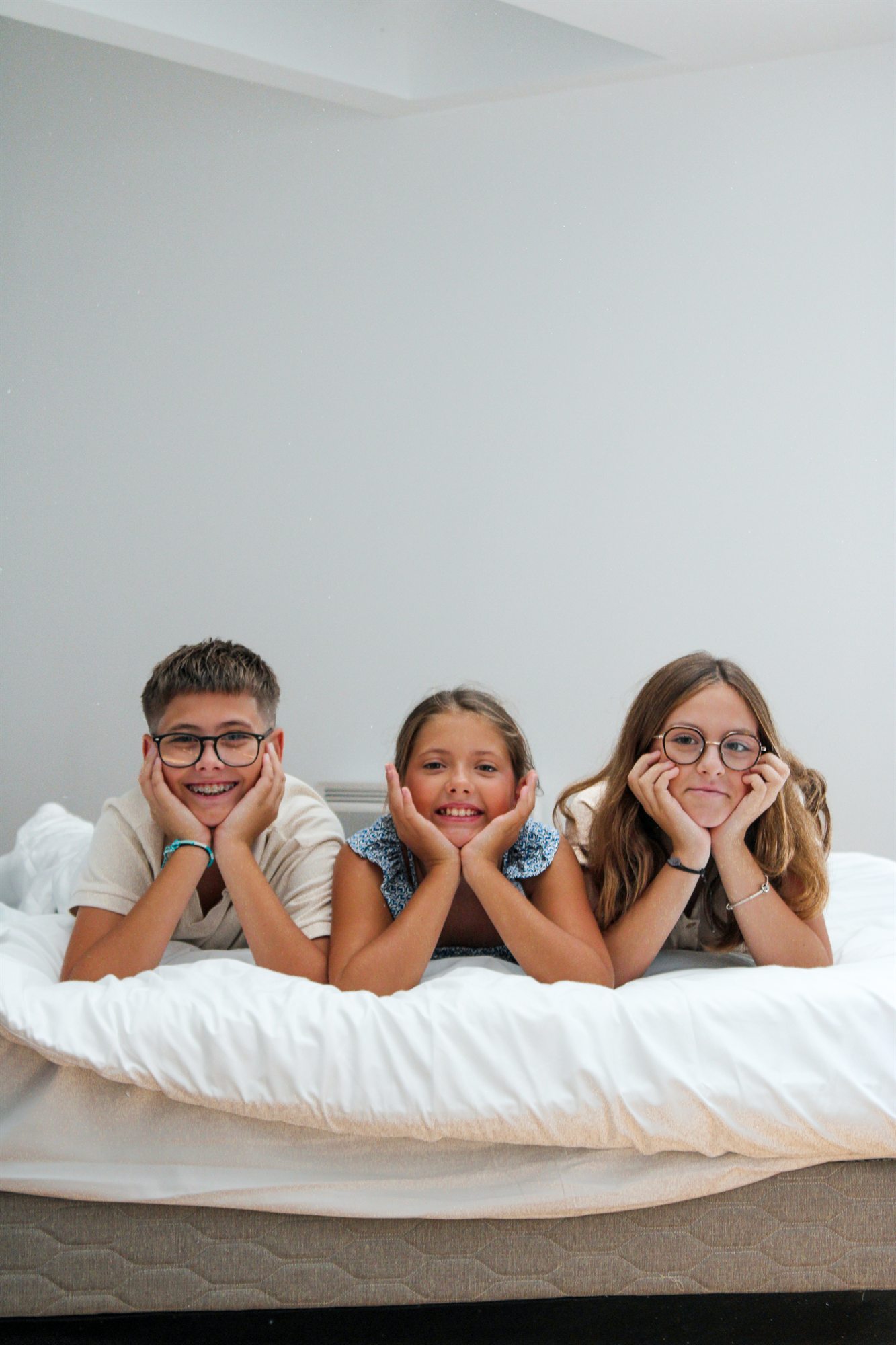 Enfants complices sur le lit de l'appartement
